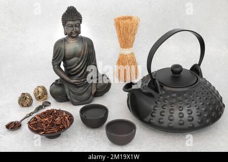 Bevanda a base di erbe Kukicha twig per la cerimonia giapponese del tè con set di teiera in ceramica e statua del Buddha. Cibo tradizionale salute e pace interiore, concetto. Foto Stock