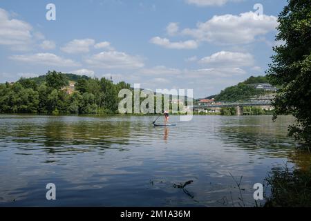 Il fiume tedesco meno con acqua pulita e donna sul loro stand up paddle board vicino alla città di Zellingen. Foto Stock