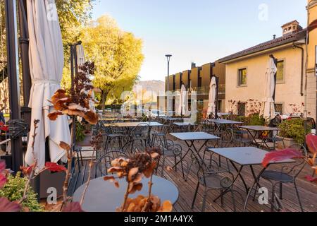 Un piccolo ristorante nel paese di Bergamo con molte sedie e un cielo blu Foto Stock