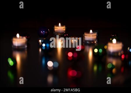 Baubles sfocato con candele a fuoco Foto Stock