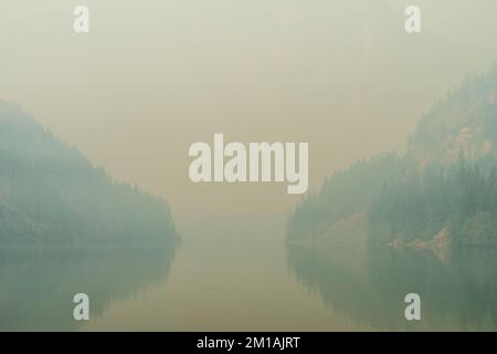 Il fumo proveniente dagli incendi boschivi si affaccia sul lago Diablo nelle Cascate del Nord Foto Stock