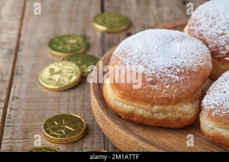 Hanukkah felice. Ciambelle dolci Hanukkah, scatole regalo, candele bianche e monete di cioccolato su vecchio sfondo di legno. Immagine e concetto di vacanza ebraica Foto Stock