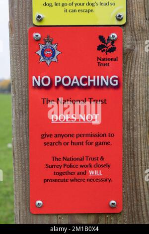 Un cartello del National Trust 'No Poaching' su un palo di recinzione a Runnymede, Surrey, Regno Unito. Foto Stock