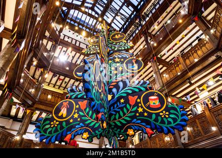 Un grande albero di Natale sospeso dal soffitto a Liberty London, Regno Unito Foto Stock