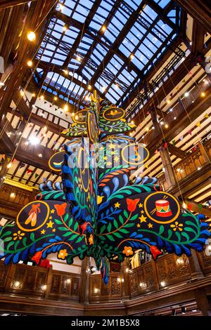 Un grande albero di Natale sospeso dal soffitto a Liberty London, Regno Unito Foto Stock