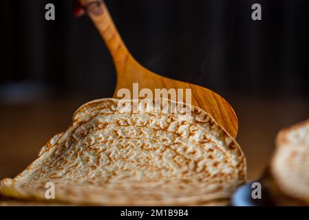 Pancake caldo appena sfornato. Spatola per frittelle di frassino. Macro fotografia di frittelle. Macro pancake. Primo piano di frittelle dolci. Colazione da una pila Foto Stock