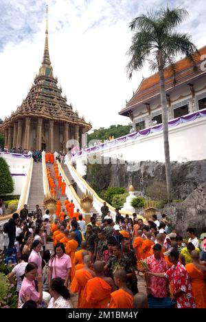 Molte persone thailandesi danno fiori ai monaci buddisti per le elemosine nella cerimonia di Tak Bat Dok mai (dare fiori ai monaci) al tempio Phrabuddhabat Woramahavihan. Foto Stock