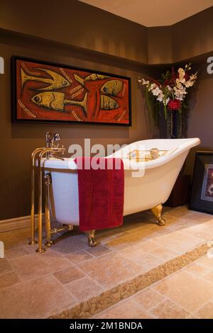 Vasca da bagno indipendente in vecchio stile su base di ceramica nel bagno seminterrato all'interno di una lussuosa casa. Foto Stock