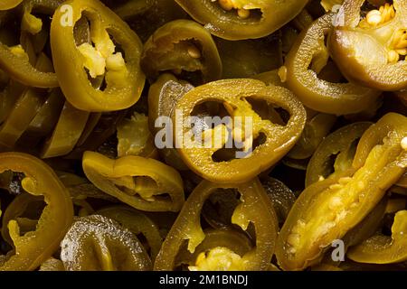 La consistenza dei peperoni jalapeno verdi tritati come sfondo. Uno shot vicino di peperoni jalapeno messicani tritati. Foto macro. Peperoni Jalapeno molto cl Foto Stock