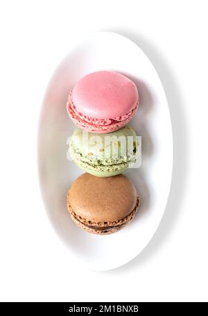 Macaron, macaron francesi in un recipiente bianco. Confezione a base di meringa dolce, stile parigino, realizzata con albume, zucchero, mandorle e coloranti alimentari. Foto Stock