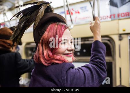New York City, New York - 11 dicembre 2022: Persone in abiti d'epoca in sella al treno di molti colori, Vacanze Nostalgia Rides, NYC Foto Stock