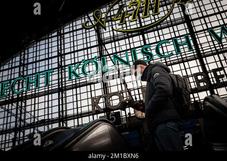 Immagine di un uomo in attesa di un treno sulle piattaforme della stazione ferroviaria di Colonia Koln hauptbahnhof, indossando maschere facciali durante il Coronavirus Covid 19 h. Foto Stock