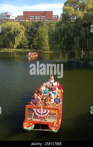 Un gruppo di persone fa un giro sulle storiche Swan Boats nel Publik Garden di Boston Foto Stock