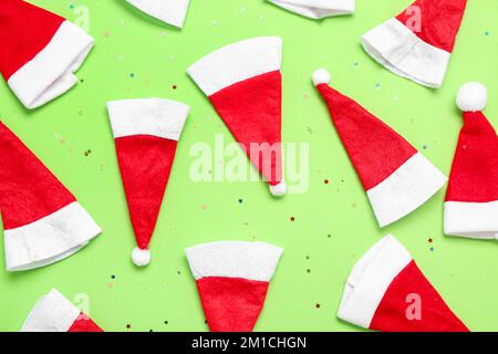 Composizione con cappelli di Santa su sfondo verde Foto Stock