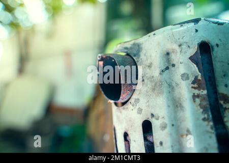 Primo piano del tubo di scarico di un trattore retrostante su uno sfondo sfocato Foto Stock