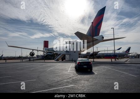 Un 2008 Pontiac G6 in esposizione davanti a un Boeing 747-400 della Delta Air Lines Foto Stock