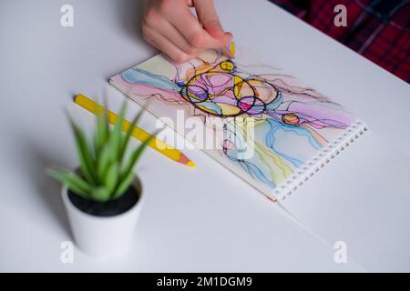 Disegno neurografico astratto con matite colorate. Primo piano delle mani che disegnano arte neurografica Neurografia colorata Foto Stock