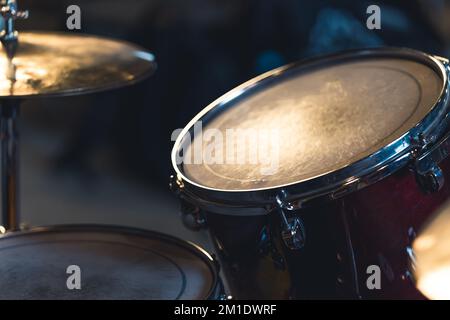 Frammento di un set di tamburi. Primo piano in interni. Attrezzature utilizzate dai musicisti in band. Leggera illuminazione. Foto di alta qualità Foto Stock