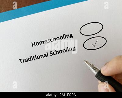 Una persona sta rispondendo alla domanda sulle risorse umane. Sceglie l'istruzione tradizionale sopra l'homeschooling. Foto Stock