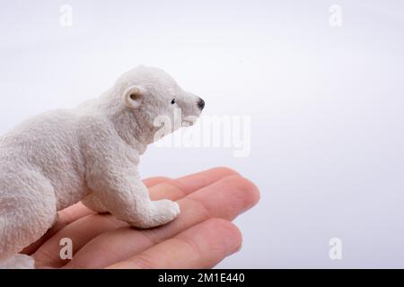 Mano che tiene un orso polare modello Foto Stock