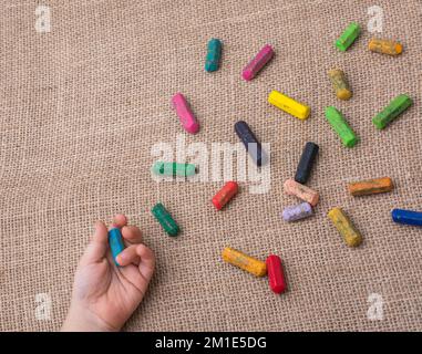 Usato pastelli di colore e una mano dei toddlers che tiene uno Foto Stock