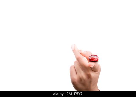 Bambino la mano che regge un auto rossa su uno sfondo bianco Foto Stock