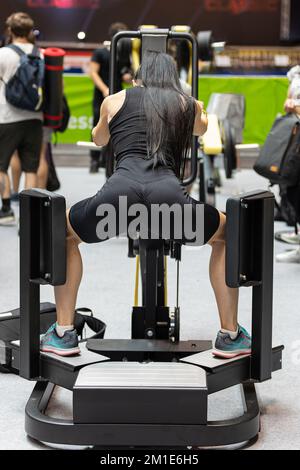 Ragazza che fa le gambe esercizi: Fitness allenamento con palestra attrezzatura. Foto Stock