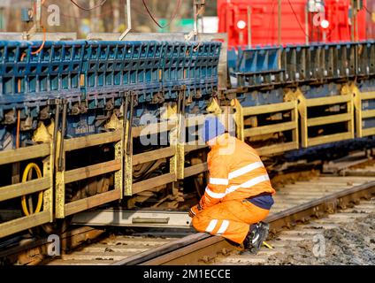 12 dicembre 2022, Schleswig-Holstein, Niebüll: Un tecnico lavora su vagoni di un autotreno deragliato. Diversi vagoni di un treno auto deragliato a Niebüll (Frisia del Nord) il Lunedi mattina. L'incidente è accaduto durante lo shunting, ha detto un portavoce della polizia federale. Di conseguenza, nessuno è stato ferito. Il traffico della navetta per Westerland su Sylt e il traffico passeggeri per Tondern in Danimarca sono stati ostacolati. Foto: Axel Heimken/dpa Foto Stock