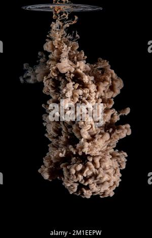 il colore acrilico marrone crea una nuvola nell'acqua. sfondo astratto. Foto Stock