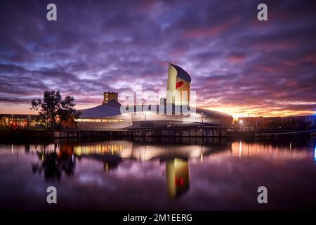 Sunset MediaCityUK Salford Quays Waterfront IWM North, Imperial War Museum North dell'architetto Daniel Libeskind Foto Stock