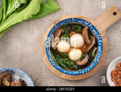 Mangiare il grande tangyuan yuanxiao (tang yuan, palle glutinose di riso gnocchi) con una zuppa saporita in una ciotola per il festival del solstizio d'inverno. Foto Stock