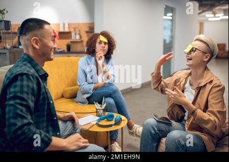 Allegra compagnia di impiegati che giocano un gioco di indovinelli Foto Stock