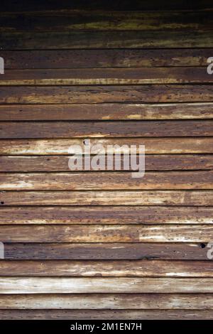 Tavole di legno intemperie che formano un motivo orizzontale con colore dal marrone scuro al chiaro dall'alto verso il basso Foto Stock