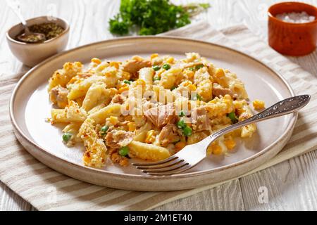 Tonno Mornay, cremoso tonno Casserole Penne Pasta Bake su piatto su tavolo di legno bianco con forchetta, vista sul paesaggio Foto Stock