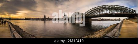 Uno scatto panoramico del Ponte Hohenzollern sul fiume Reno al tramonto panoramico a Colonia, in Germania Foto Stock