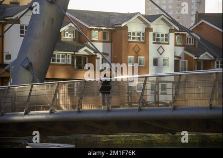 LONDRA - 4 novembre 2020: La donna usa la fotocamera per smartphone sulla passerella di South Quay, Canary Wharf Foto Stock