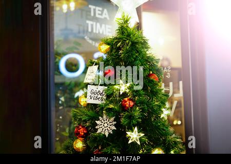 Decorazioni di Natale sull'albero di festa con un'etichetta buona virbes citazione. Festivo sfondo tradizionale celebrazione per il nuovo anno Foto Stock