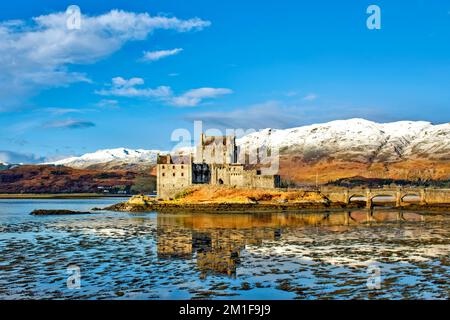 Eilean Donan Castello Dornie Scozia su una piccola isola di Loch Duich con nevicate invernali sulle colline Foto Stock