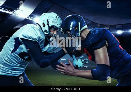 Inizio della competizione. Due calciatori americani in uniforme in piedi faccia a faccia allo stadio con torce. Concetto di sport, movimento Foto Stock