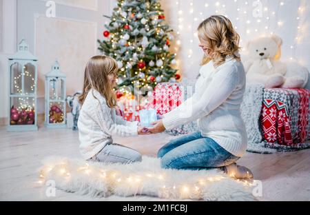 Famiglia vigilia di natale mamma e figlia aperto doni Foto Stock