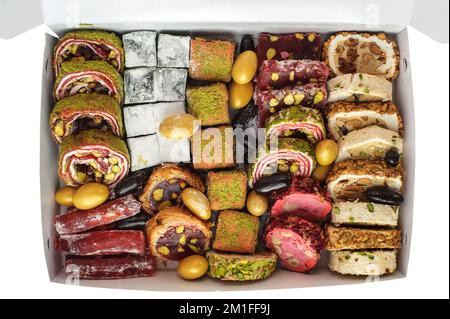 Mix di vari pezzi di tradizionale delizia turca in confezione scatola di consegna isolato su sfondo bianco. Dolci orientali. Foto Stock