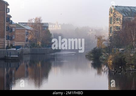 Leith, Edimburgo, Scozia, Regno Unito, 12th dicembre 2022. UK Weather: Sole e nebbia. In una giornata di freddo intenso con la temperatura che non sale oltre lo zero gradi, il sole splende sull'acqua di Leith con la nebbia gelida che oscura la vista in lontananza. Credit: Sally Anderson/Alamy Live News Foto Stock