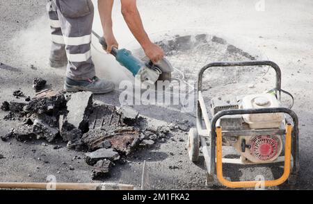 radiale nelle mani di asfaltatore taglia il suolo e generatore elettrico portatile Foto Stock