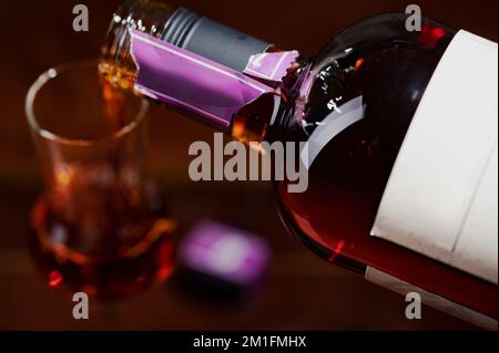 Versare l'alcol nel bicchiere Foto Stock