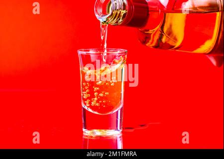 Versare l'alcol nel bicchiere Foto Stock