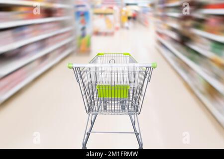carrello con astratto movimento sfocatura supermercato discount negozio corridoio e prodotti scaffali interni defocused sfondo Foto Stock