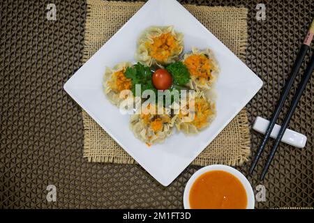 Siomay è un piatto indonesiano composto da un pesce al vapore o gnocchi di maiale con verdure servite in salsa di arachidi Foto Stock