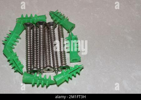 Ancoraggi autoperforanti in plastica per pareti a secco con viti autofilettanti a testa piatta Phillips Foto Stock