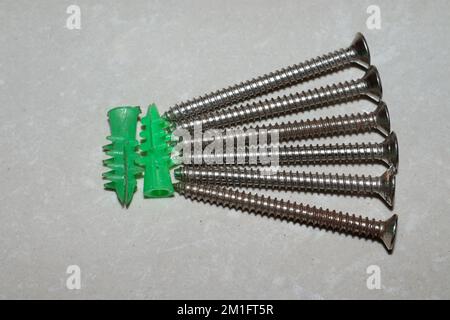 Ancoraggi autoperforanti in plastica per pareti a secco con viti autofilettanti a testa piatta Phillips Foto Stock