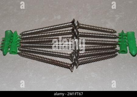 Ancoraggi autoperforanti in plastica per pareti a secco con viti autofilettanti a testa piatta Phillips Foto Stock